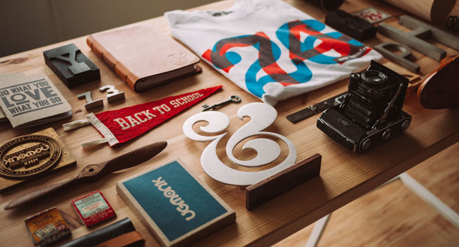 Branded print materials and merchandise on a wooden table
