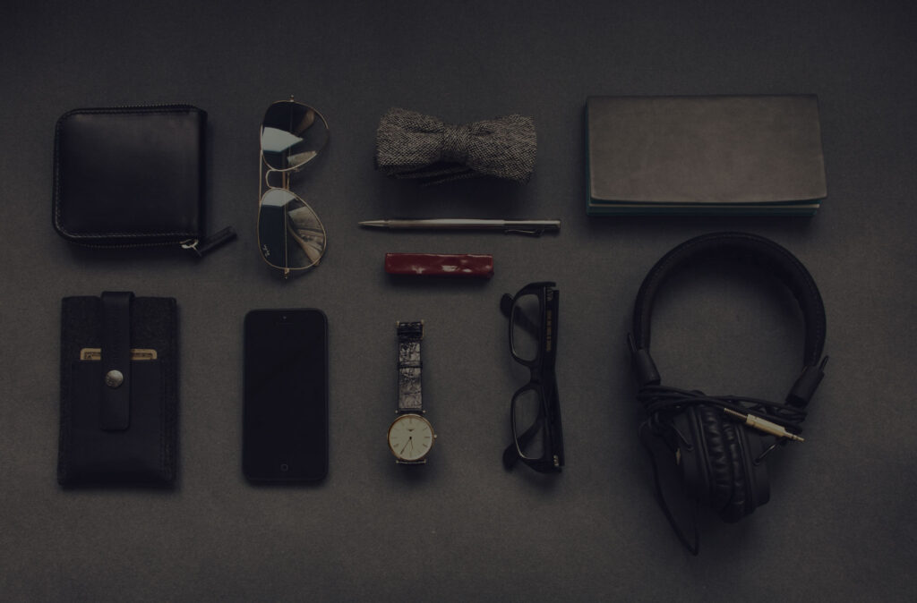 Phone, headphones, notebook and everyday tech on a dark surface